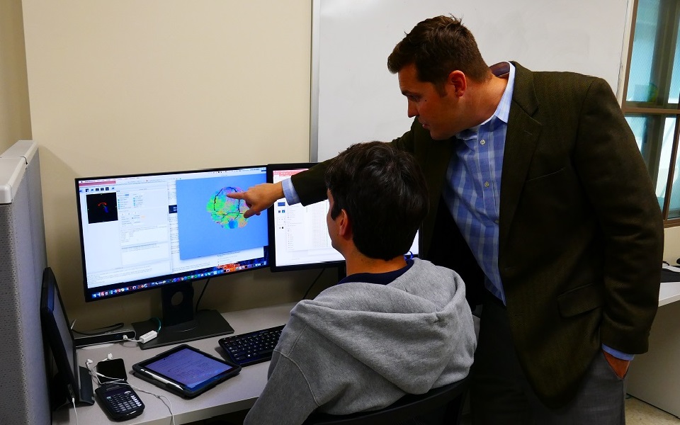 Reuben Kraft observing a brain model with a graduate student