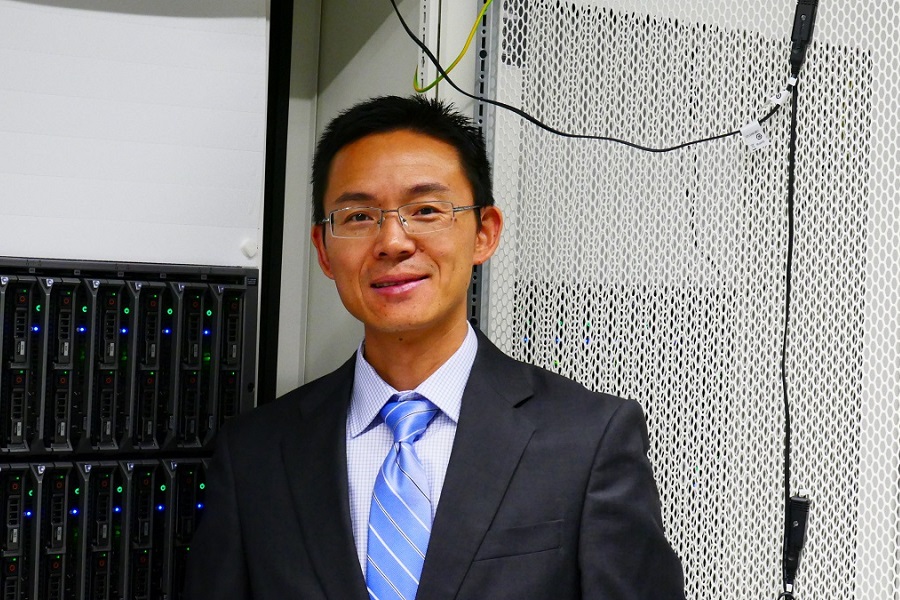 Xiaofeng Liu in front of computational hardware