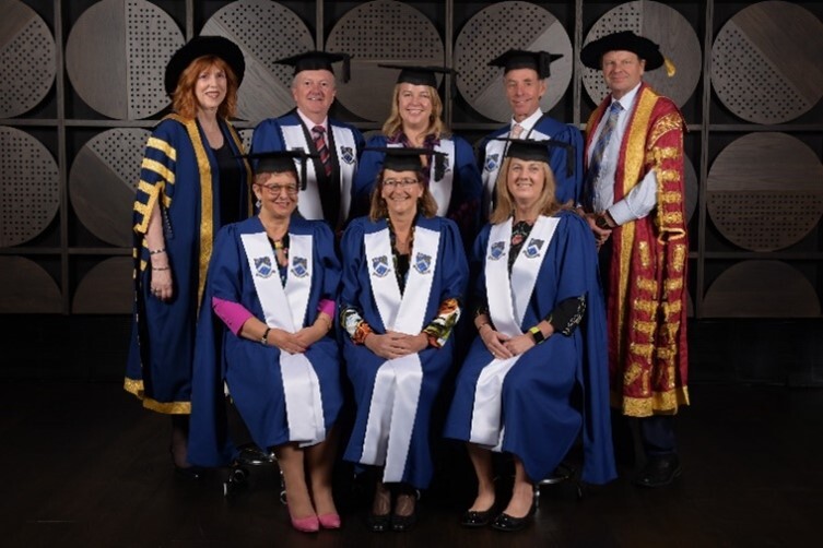fellowship winners pose in traditional academic robes